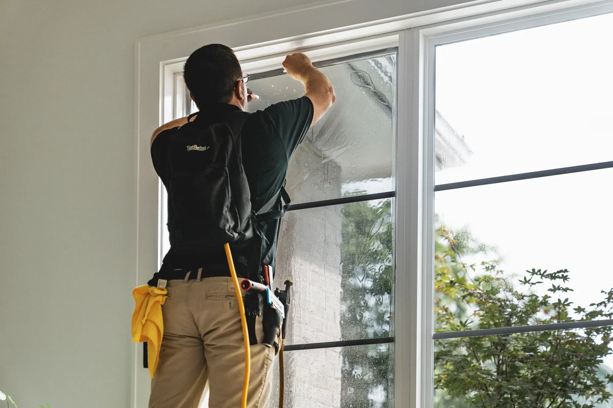 Professional installer applying architectural window film
